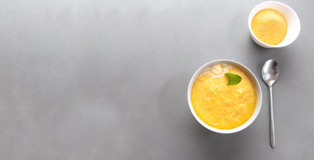 Polento corn porridge on a gray background in a gray plate. Top view. Copy space for textの写真素材