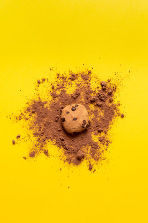 Chocolate chip cookies on a yellow background. With a splash of cocoa