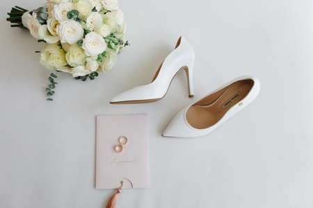 brides accessories. Bridal bouquet and bridal shoes on light background. Top view.の写真素材