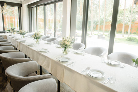 Wedding reception table in the restaurant decorated with white candles and flowers.の写真素材