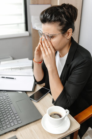 A young and beautiful businesswoman, tired of working in an office. Exhausted business lady at work in the officeの写真素材