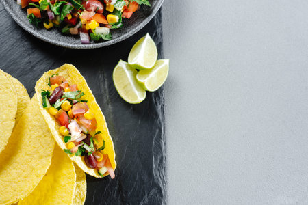 Homemade vegan tacos with black beans, corn and vegetables. The concept of clean eating, plant-based...