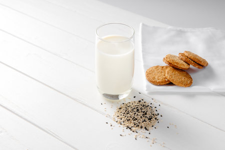 Vegan alternative food, sesame non-dairy milk with cookies on white wooden background, copy spaceの写真素材