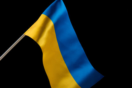 Flag of Ukraine on dark background is developing in the wind. Yellow and blue, the colors of the...