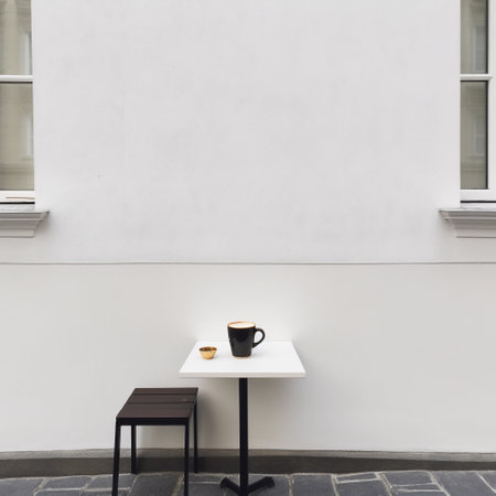 A white table with a black coffee cup on itの素材