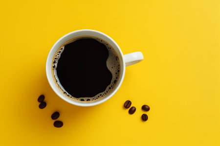 Coffee cup and coffee beans on yellow background, top viewの素材