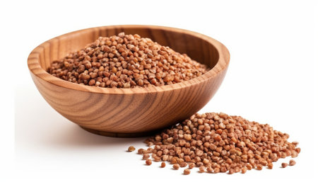 Buckwheat groats in wooden bowl isolated on white backgroundの素材