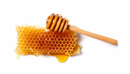 Honeycombs and wooden drizzler isolated on white backgroundの素材