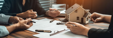 Real estate agent or real estate agent is presenting house model to customer to sign contract.の素材