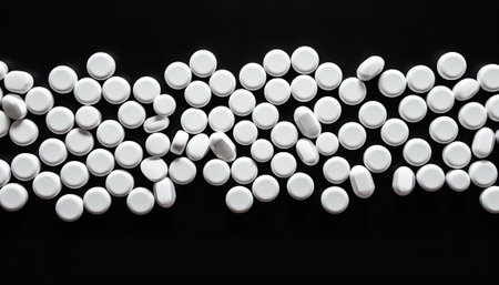 many white pills on a black background, close-up, top viewの素材