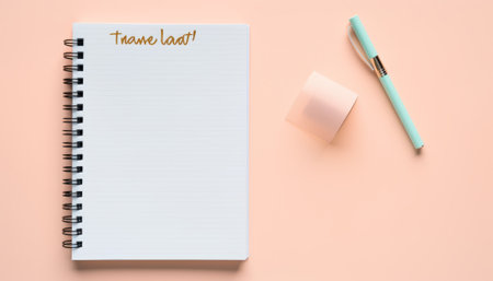 Top view of notebook with pen and marshmallow on pastel pink backgroundの素材