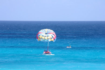 CANCUN, MEXICO - DECEMBER 05: Parasailing in a blue sky over Caribbean sea in Cancun on December 05, 2011. Parasailing is a popular recreational activity among tourists in Cancun, Mexicoのeditorial素材