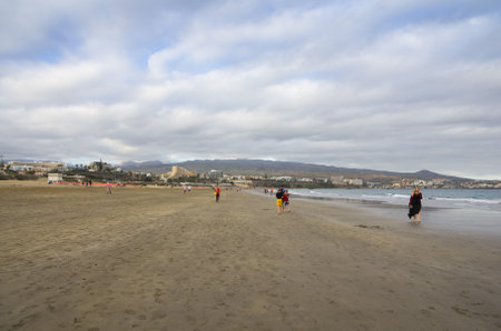 GRAN CANARIA, CANARY ISLANDS - JANUARY 01, 2014: Unidentified people walking from Playa del Ingles to Maspalomas along the coast of Atlantic ocean, Gran Canaria, Canary islands, Spainのeditorial素材