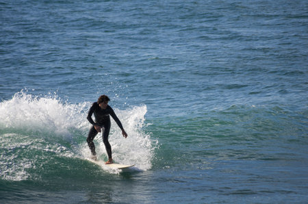 GRAN CANARIA, CANARY ISLANDS - JANUARY 05, 2014: Unidentified man surfing on a large wave on Playa del Ingles on the coast of Atlantic ocean, Gran Canaria, Canary islands, Spainのeditorial素材