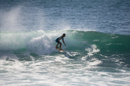 GRAN CANARIA, CANARY ISLANDS - JANUARY 05, 2014: Unidentified man surfing on a large wave on Playa del Ingles on the coast of Atlantic ocean, Gran Canaria, Canary islands, Spainのeditorial素材