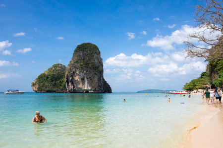 AO NANG BEACH, CRABI PROVINCE, THAILAND - FEBRUARY 02, 2015: Tourists relaxing on Railay beach surrounded by limestone cliffs in Ao Nang, Krabi province, Thailandのeditorial素材
