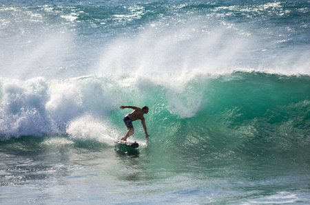 GRAN CANARIA, CANARY ISLANDS - JANUARY 05, 2014: Unidentified man surfing on a large wave on Playa del Ingles on the coast of Atlantic ocean, Gran Canaria, Canary islands, Spainのeditorial素材