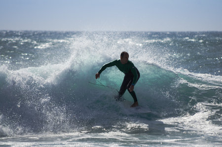 GRAN CANARIA, CANARY ISLANDS - JANUARY 05, 2014: Unidentified man surfing on a large wave on Playa del Ingles on the coast of Atlantic ocean, Gran Canaria, Canary islands, Spainのeditorial素材