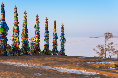 Wooden ritual pillars with colorful ribbons on Olkhon Island, Lake Baikal, Siberia, Russiaの写真素材