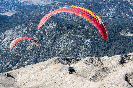 KEMER, TURKEY - OCTOBER 22, 2017: Paragliders flying over mountains near Kemer, a seaside resort on the Turkish Riviera in Antalya Province, Turkeyのeditorial素材
