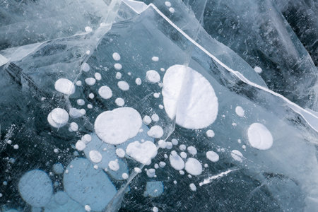 Gas methane bubbles frozen in blue ice of lake Baikal, Siberia, Russiaの写真素材