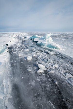 Ice of Lake Baikal, the deepest and largest freshwater lake by volume in the world, located in...