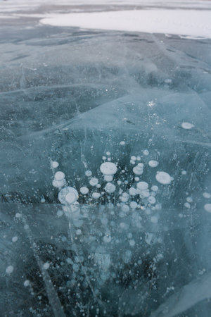 Gas methane bubbles frozen in blue ice of lake Baikal, Siberia, Russiaの写真素材