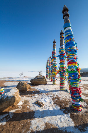 Wooden ritual pillars with colorful ribbons on cape Burkhan, Lake Baikal, Olkhon Island, Siberia, Russiaの写真素材