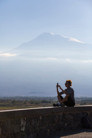 ARMENIA - OCTOBER 08, 2021: View of unidentified women taking photos of Mount Ararat on sunset,...