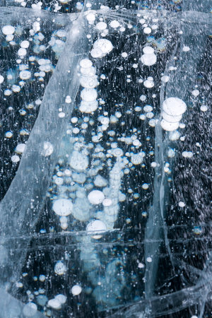 Gas methane bubbles frozen in blue ice of lake Baikal, Siberia, Russiaの写真素材