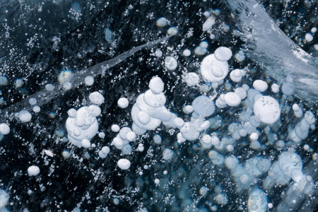 Gas methane bubbles frozen in blue ice of lake Baikal, Siberia, Russiaの写真素材