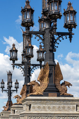 HRYASCHEVKA VILLAGE, SAMARA REGION, RUSSIA - AUGUST 01, 2023: The row of openwork lampposts decorated with sculptures of griffins in the tourist complex Garibaldi Castle against blue cloudy skyのeditorial素材
