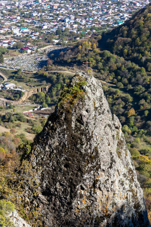 A rock with a Christian cross on top above the village named after Kosta Khetagurov in a mountain...