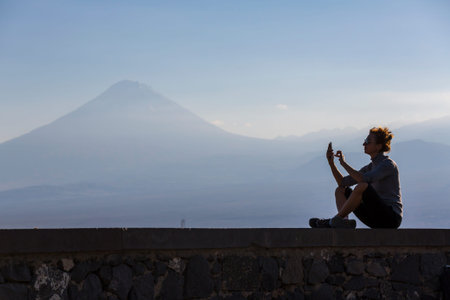 ARMENIA - OCTOBER 08, 2021: View of unidentified women taking photos of Mount Ararat on sunset, Armeniaの写真素材