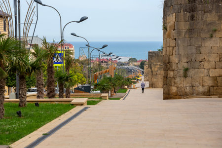 DERBENT, DAGESTAN REPUBLIC, RUSSIA - SEPTEMBER 26, 2023: A view of the pedestrian promenade along the old fortress wall in the historic center of Derbent. The Caspian Sea is in the backgroundのeditorial素材