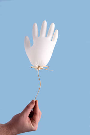 Hand holding medical glove as balloon. Abstract medical conceptの写真素材