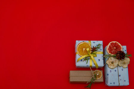 Christmas gifts in corner on red background. Flat lay