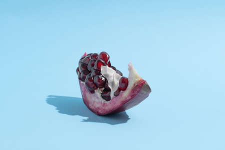 Pomegranate in shape of boat. Blue background. Creative fruit backgroundの写真素材