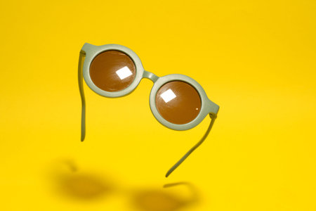 Funny round retro green sunglasses for kids on yellow background