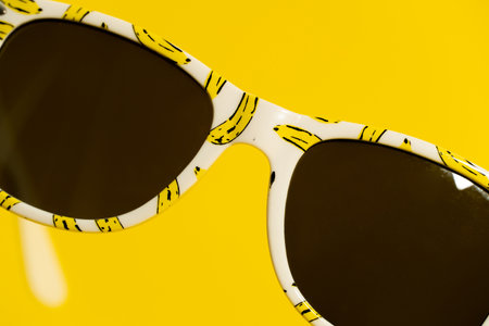 Funny banana floating sunglasses for kids on yellow backgroundの写真素材
