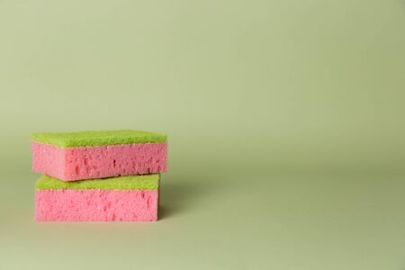 Two pink sponges on a green background. Copy space. Place for text.の写真素材