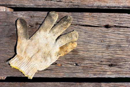 dirty cotton work glove on the wooden floor