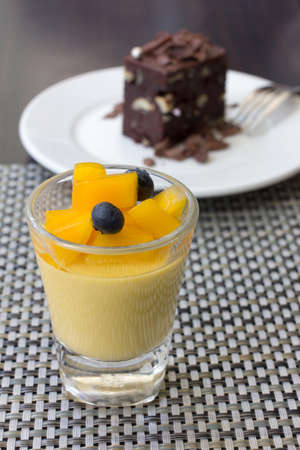 mango pudding in a glass and chocolate brownie as background, canape appetizerの写真素材