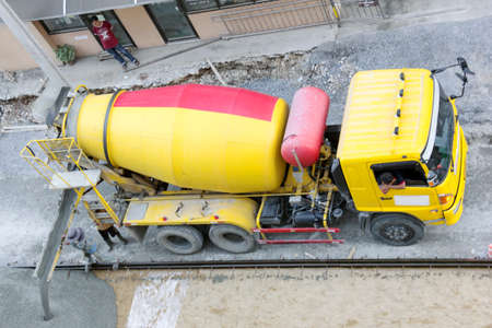 Construction worker pouring concrete from cement truckの写真素材