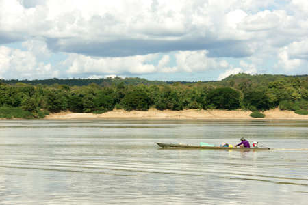 Fisherman in a long tailed boat at the Mekong Riverの写真素材
