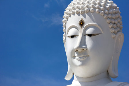 head of white buddha against blue skyの写真素材