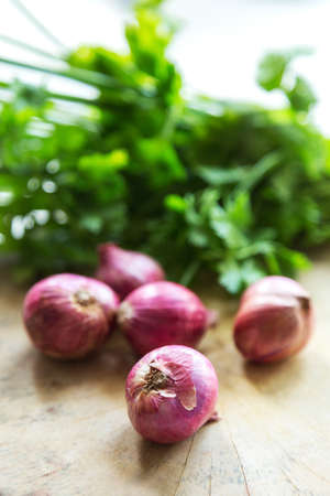shallots on wooden cutting board, selective focusの写真素材