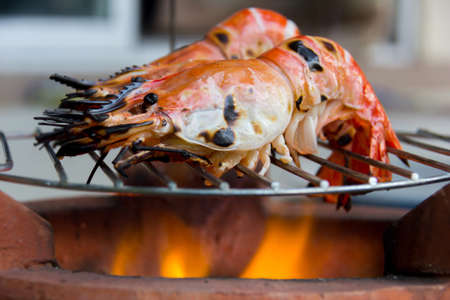grilling giant freshwater prawn on a charcoal brazier with selected focusの写真素材