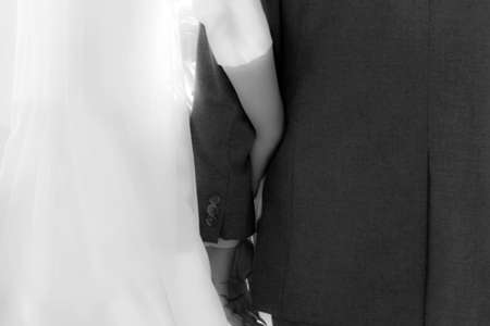 bride and groom holding hands at the wedding, black and white photoの写真素材