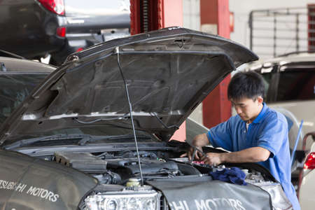 Bangkok, Thailand - January 21 : automobile mechanic examining car suspension of lifted  automobile at at Mitsubishi Motor Service station on January 21, 2015. Bangkok, Thailand.のeditorial素材